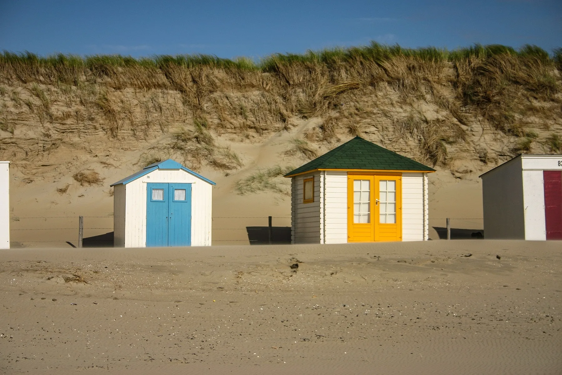 Bunte Strandhäuschen vor den Texeler Dünen